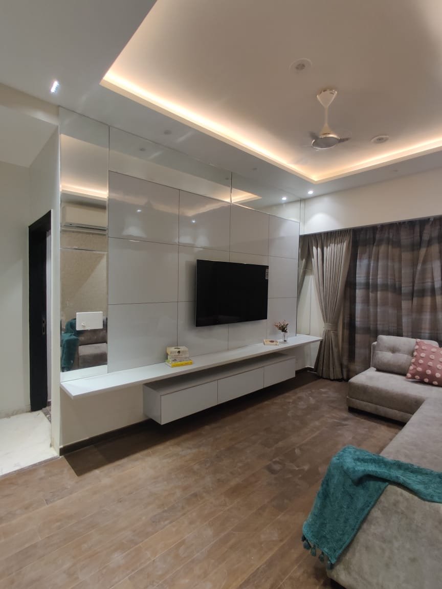 Stylish lounge area featuring a soft beige sofa, elegant drapes, and textured walls.